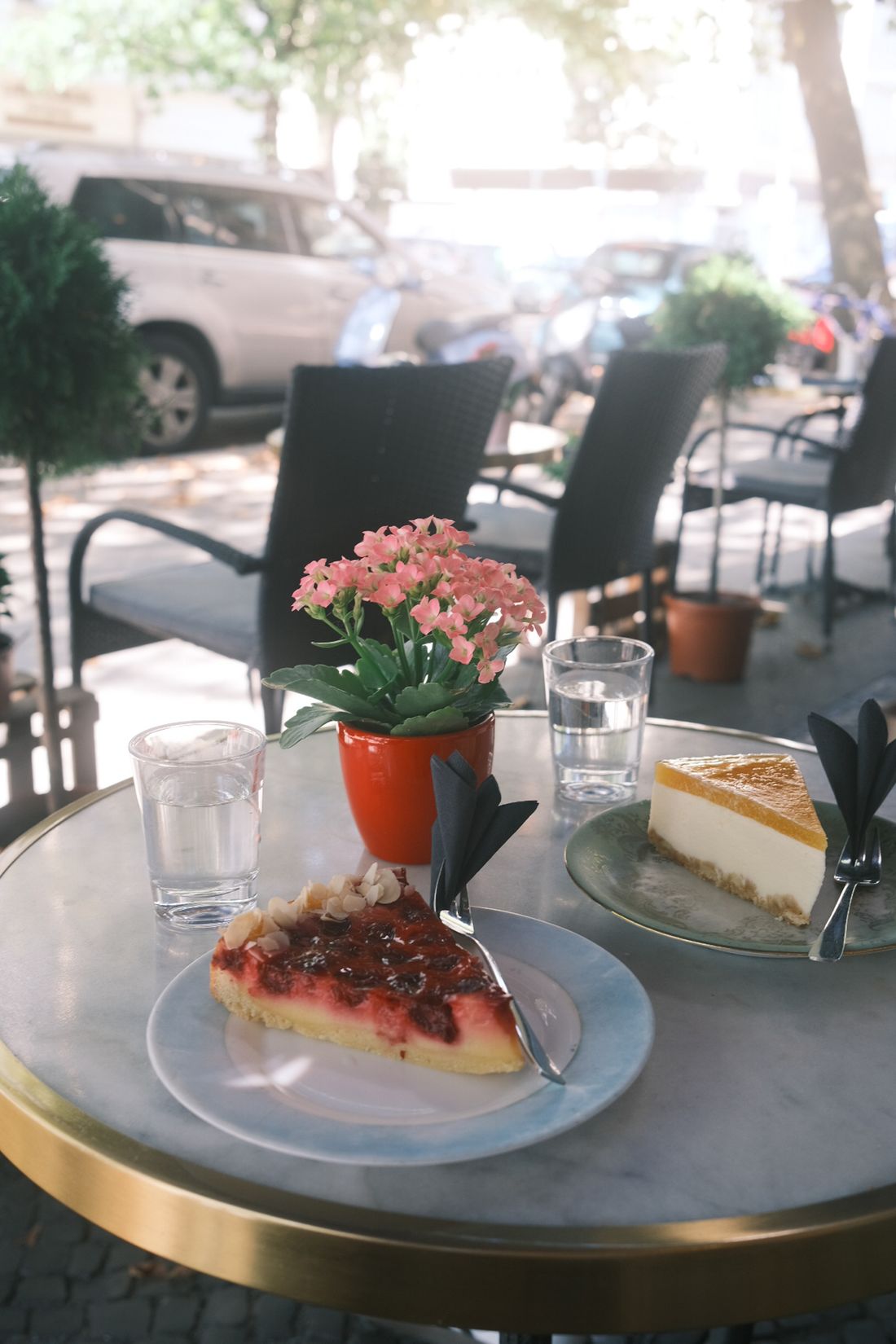 Frische Kuchenstücke und Blumen auf dem Terrassentisch